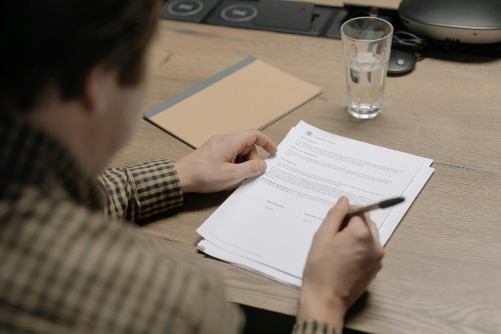 Close-up of hands reviewing contract documents on a desk