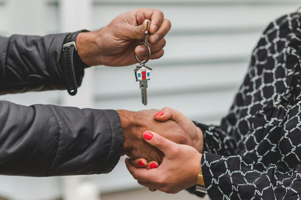 Real estate agent handing over house keys for license verification in Toronto