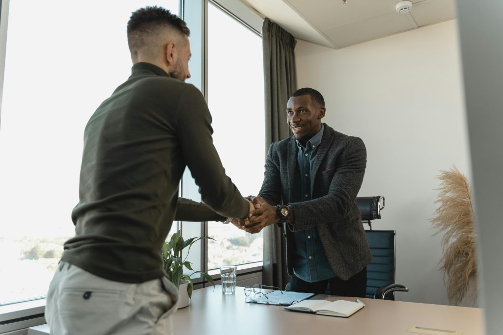 Two professionals shaking hands during a business meeting in Toronto real estate office